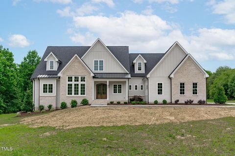 Bring your horses with country living in the heart of Wake County! Standing out among one the Triangle's most impressive custom-built new construction residences is a ranch-style home nestled on nearly 14 acres of level land, with no HOA restrictions...