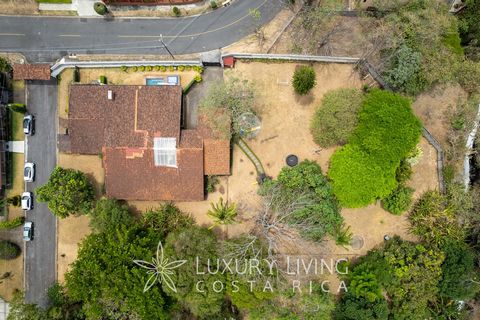 Welcome to Casa Riverine, a serene property located in the prestigious residential neighborhood of Bosques de Doña Rosa in Cariari, Belén de Heredia. This charming single-level home is situated on a vast plot surrounded by lush gardens and bordered b...