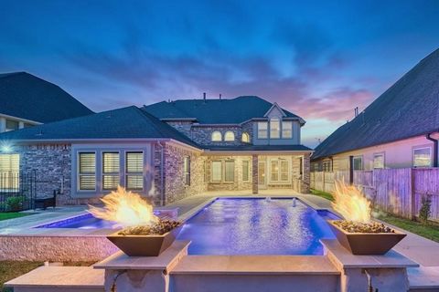 Luxurious Coventry design in the Master-Planned Cane Island; zoned to Katy ISD schools. BACKYARD RESORT boasts HEATED IN-GROUND POOL & SPA w/fire & water features, + TX-sized covered patio w/OUTDOOR KITCHEN! Covered front porch w/dbl 8' doors welcome...