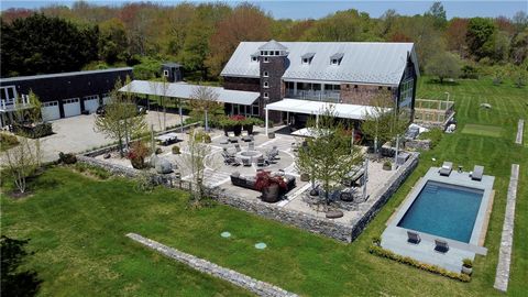 Situated on over 9 pastoral acres, this contemporary home is designed to capture an abundance of natural light through its south-facing floor-to-ceiling doors and windows. Nestled in privacy next to Aquidneck Land Trust property, the residence featur...