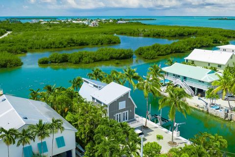Bright and spacious Summerland Key beach cottage retreat, on a peaceful corner lot, with endless turquoise Water Views! This prime location is ideal for the avid boater, outfitted with all the necessities including 120' seawall, 17K boat lift, 7500 l...