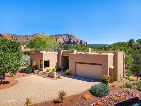 Welcome to a highly crafted home designed by Paul Overman and built by Casa Natural Builders. This charming southwest contemporary home has many upgrades complete with porcelain floors, cherry wood entertainment bar with red rocks views, alder wood d...