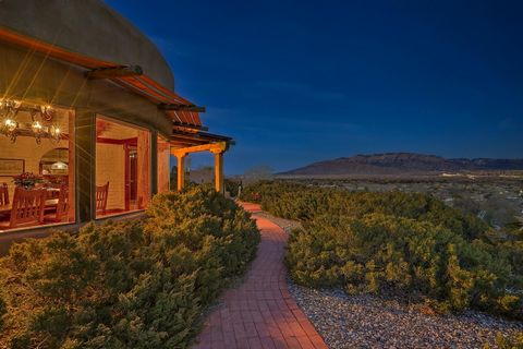Distinctive custom adobe style casa with panoramic views of the Sandia Mountains, bosque and city. Passive solar adobe construction and herringbone brick flooring that run throughout this one-owner house are the hallmarks of the property's architectu...
