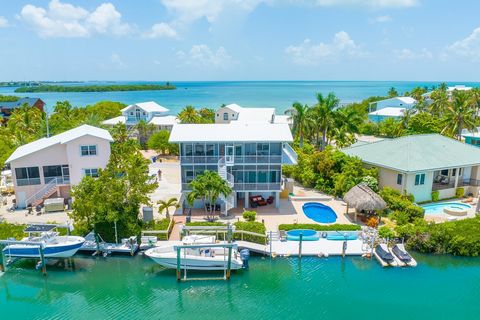 Welcome to this stunning waterfront home located in the beautiful Florida Keys. This three-story concrete structure with elevator to all 3 floors is a true gem. Situated within a gated subdivision, it offers the utmost privacy and security for its re...