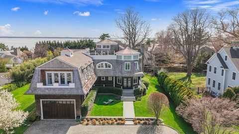 This ultra-luxurious, custom built shingle-style Contemporary delivers breathtaking water views from its chic, updated interior and multi-level decks only steps from the private sandy beach in Orienta Point. This architecturally significant home, des...